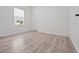 A bedroom featuring sleek wood-look floors, a window with blinds, and a white door at 2249 Litchfield Loop, Deland, FL 32720