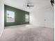 Large bedroom featuring a ceiling fan, plush carpet and accent wall with natural lighting at 2249 Litchfield Loop, Deland, FL 32720
