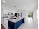 Bright kitchen features a navy blue island, stainless steel appliances, granite countertops, and modern backsplash at 2249 Litchfield Loop, Deland, FL 32720