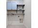 Laundry room with blue cabinets, wood shelves, and patterned wallpaper at 2249 Litchfield Loop, Deland, FL 32720