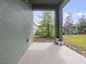 A covered patio with a view of a well-maintained lawn and landscaping at 2249 Litchfield Loop, Deland, FL 32720