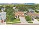 Aerial view of a house with a brown roof, green lawn, driveway, and two-car garage at 2250 Blossomwood Dr, Oviedo, FL 32765