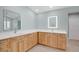 Bright bathroom with double vanities featuring wooden cabinets, quartz countertops, and modern mirrors at 2250 Blossomwood Dr, Oviedo, FL 32765