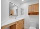 Bright bathroom with white vanity, wood cabinets, decorative mirrors, and modern fixtures at 2250 Blossomwood Dr, Oviedo, FL 32765