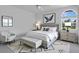 Bright bedroom features a king bed, a tufted bench, modern decor, and lots of natural light at 2250 Blossomwood Dr, Oviedo, FL 32765