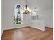 Bright dining room featuring wood floors, modern chandelier, and arched window with white curtains at 2250 Blossomwood Dr, Oviedo, FL 32765
