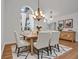 Elegant dining room with wooden table, six chairs, chandelier, and decorative art next to arched window at 2250 Blossomwood Dr, Oviedo, FL 32765