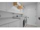 Well-organized laundry room with white cabinets, quartz countertops, and modern washer and dryer at 2250 Blossomwood Dr, Oviedo, FL 32765