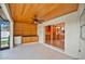 Covered patio with wood ceiling, ceiling fan, and view of kitchen through sliding glass door at 2250 Blossomwood Dr, Oviedo, FL 32765