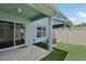 Private backyard with artificial grass, a covered patio, and sliding glass doors at 2337 Bexley Pl, Casselberry, FL 32707