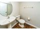 Cozy half-bathroom with a modern pedestal sink, decorative mirror, and tiled floor at 2337 Bexley Pl, Casselberry, FL 32707