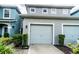 Two-car garage of townhome with grey exterior paint and well-manicured shrubbery at 2337 Bexley Pl, Casselberry, FL 32707