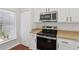 Modern kitchen featuring stainless steel appliances and white cabinets with black hardware at 2337 Bexley Pl, Casselberry, FL 32707