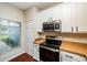 Kitchen with stainless steel oven, microwave, and white cabinetry at 2337 Bexley Pl, Casselberry, FL 32707