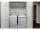 This practical laundry area features a washer, dryer, and upper shelf for supplies, all enclosed by white bi-fold doors at 2337 Bexley Pl, Casselberry, FL 32707
