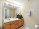 Bright bathroom featuring a wooden vanity, neutral walls, and a large mirror at 2409 Silver Palm Dr, Kissimmee, FL 34747