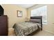 Neutral-toned bedroom featuring a queen-sized bed, tile flooring, and a large window at 2409 Silver Palm Dr, Kissimmee, FL 34747