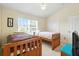 Bright bedroom with two wooden beds, a vaulted ceiling, and a window with blinds at 2409 Silver Palm Dr, Kissimmee, FL 34747