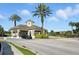 Community entrance with a small guard house, palm trees, landscaping and a vehicle waiting to enter at 2409 Silver Palm Dr, Kissimmee, FL 34747