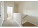 Upstairs hallway leading to the bedrooms with carpet flooring and access to storage at 2409 Silver Palm Dr, Kissimmee, FL 34747