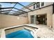 Inviting screened pool with brick decking and sliding glass doors to the home's interior at 2409 Silver Palm Dr, Kissimmee, FL 34747