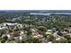 Aerial view of a neighborhood with mature trees, showcasing community pool, surrounding buildings, and a lake at 271 Raintree Dr, Casselberry, FL 32707