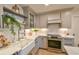 Farmhouse sink with stainless appliances and open shelving create a modern kitchen look at 271 Raintree Dr, Casselberry, FL 32707