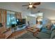 Living room with vaulted ceiling, ceiling fan, and open view into kitchen at 271 Raintree Dr, Casselberry, FL 32707