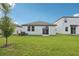 Spacious backyard with lush green grass, patio, and white exterior at 2770 Virginia Pine Dr, Bartow, FL 33830