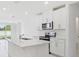Bright kitchen features white cabinets, stainless steel appliances and a large kitchen island with sink at 2770 Virginia Pine Dr, Bartow, FL 33830