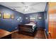 Bedroom features a ceiling fan, dark blue walls and wood-look flooring at 283 Haverclub Ct, Longwood, FL 32779