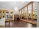Bright living room with dark wood floors, a chandelier, and a wall of mirrors reflecting the open layout at 283 Haverclub Ct, Longwood, FL 32779