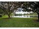 Scenic pond view framed by mature trees and a sprawling green lawn at 283 Haverclub Ct, Longwood, FL 32779