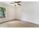 A well-lit bedroom with a ceiling fan, tiled floor and large window at 2838 Maldive Ct, Deltona, FL 32738