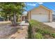 Tan single-story home featuring an attached garage, well-kept shrubs, and mature landscaping at 2838 Maldive Ct, Deltona, FL 32738