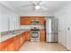 Kitchen featuring stainless steel appliances, wood cabinets, and tile flooring at 2838 Maldive Ct, Deltona, FL 32738