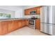 Well-lit kitchen features stainless steel appliances, tile flooring, and wood cabinetry at 2838 Maldive Ct, Deltona, FL 32738