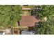 Birds-eye view of a home with a brown roof, mature trees, and a fenced backyard at 2935 Canoe Cir, St Cloud, FL 34772