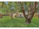 Large backyard featuring green grass, mature trees providing ample shade, and a wooden fence for privacy at 2935 Canoe Cir, St Cloud, FL 34772