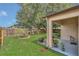 Expansive backyard featuring lush green grass, a wooden fence, a concrete patio, and manicured landscaping at 2935 Canoe Cir, St Cloud, FL 34772