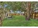 Spacious backyard with mature trees, lush lawn, wooden fencing, and landscaping beds at 2935 Canoe Cir, St Cloud, FL 34772