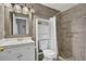Cozy bathroom with a walk-in shower, white vanity with chrome hardware, and framed mirror with decorative lighting at 2935 Canoe Cir, St Cloud, FL 34772
