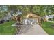 Charming home featuring a two-car garage, well-manicured lawn, and mature trees providing shade at 2935 Canoe Cir, St Cloud, FL 34772