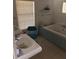 Cozy bathroom featuring a tiled bath, single sink, and large window at 310 W Lake Ave, Auburndale, FL 33823