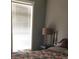Bright bedroom featuring a floral comforter, bedside table, and a window with natural light at 310 W Lake Ave, Auburndale, FL 33823