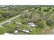 Aerial view displays the home, surrounded by lush greenery and a spacious fenced-in yard at 369 Bluff Lake Rd, Mascotte, FL 34753