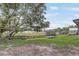 Backyard with a swing, trampoline, storage shed, and a lake view offers recreational opportunities at 369 Bluff Lake Rd, Mascotte, FL 34753