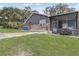 Exterior showcases a well-maintained lawn, stone accents, red door, and enclosed patio at 369 Bluff Lake Rd, Mascotte, FL 34753