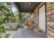 Covered front porch showcasing stone facade, flowering vines and a rocking chair at 369 Bluff Lake Rd, Mascotte, FL 34753