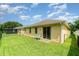 Spacious backyard with green lawn and small patio outside sliding glass door, perfect for relaxation and entertaining at 3896 Esplanade Ave, Port Orange, FL 32129